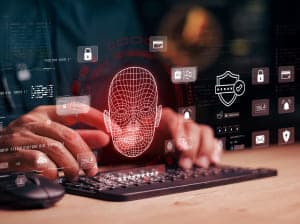 A person working at a laptop keyboard with a series of icons on the translucent screen