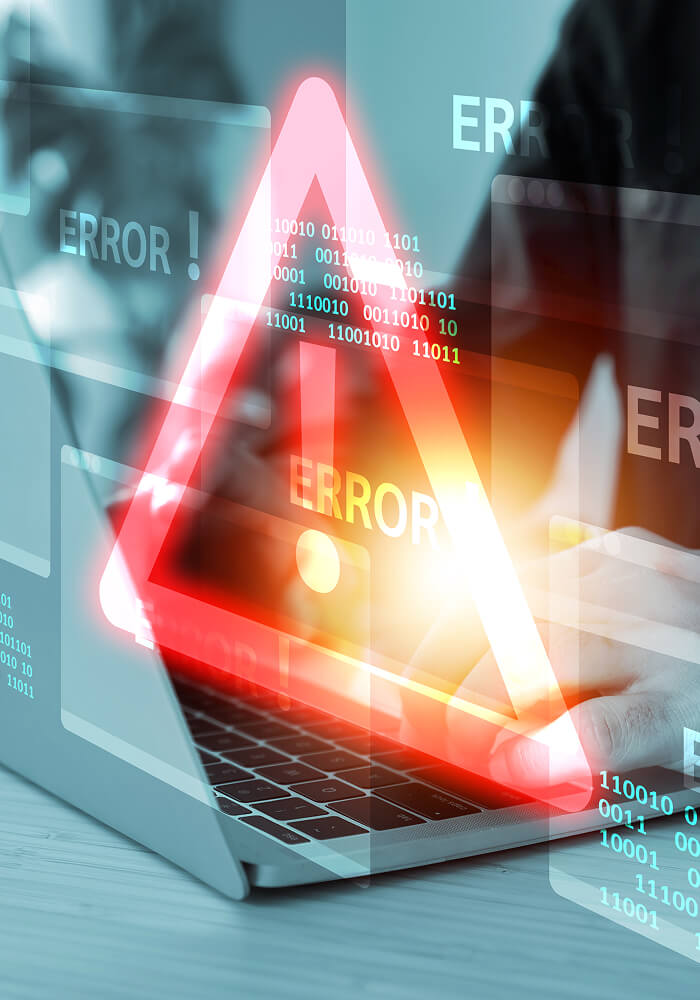 Person working on a laptop with a large, red alert sign overlaying on top