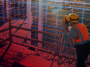 A construction worker standing on a balcony overlooking a digital grid on site.