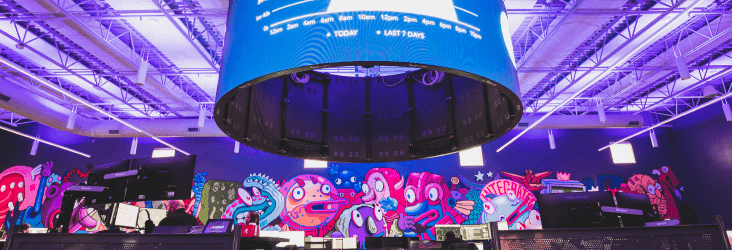 Digitized graph on a circular display screen hanging from the ceiling. Graphics and graffiti on the back wall.