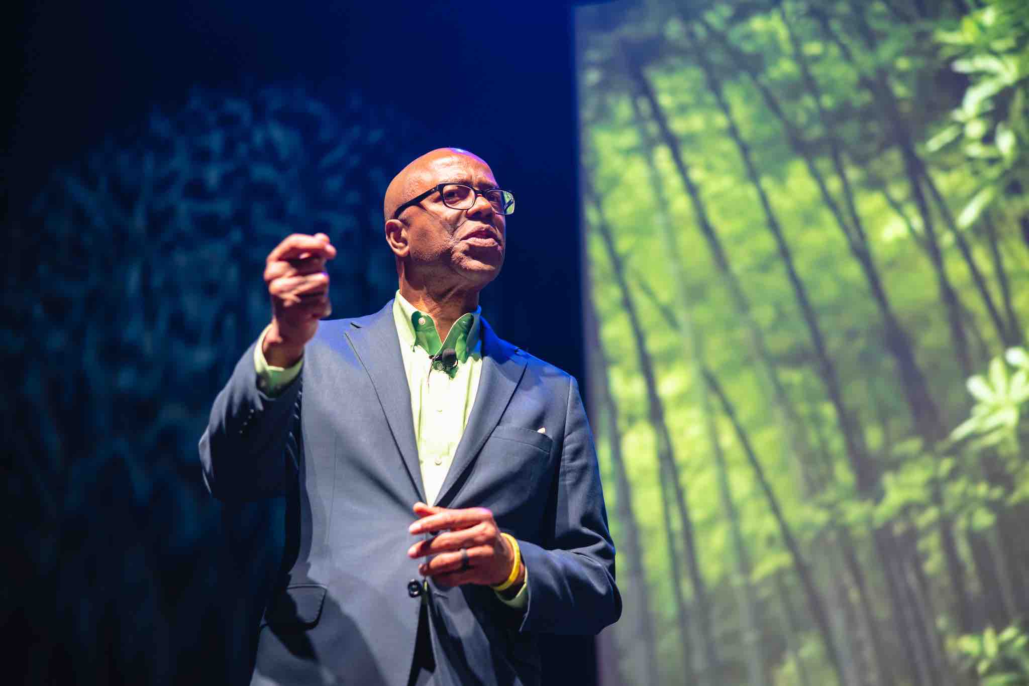 man on stage with his right hand extended