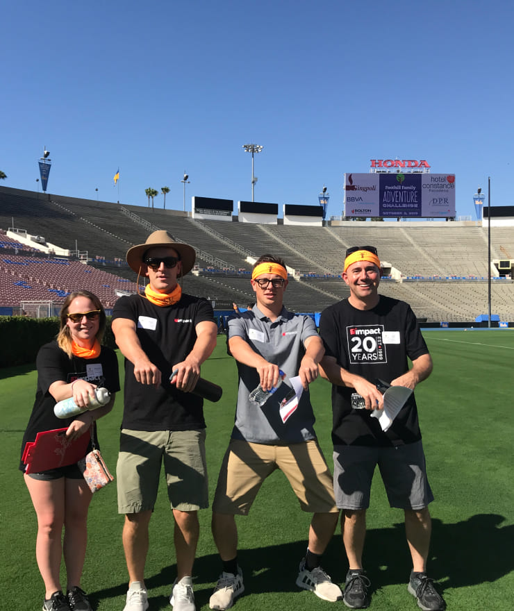 four people at the Rose Bowl in Pasadena California posing for a photo