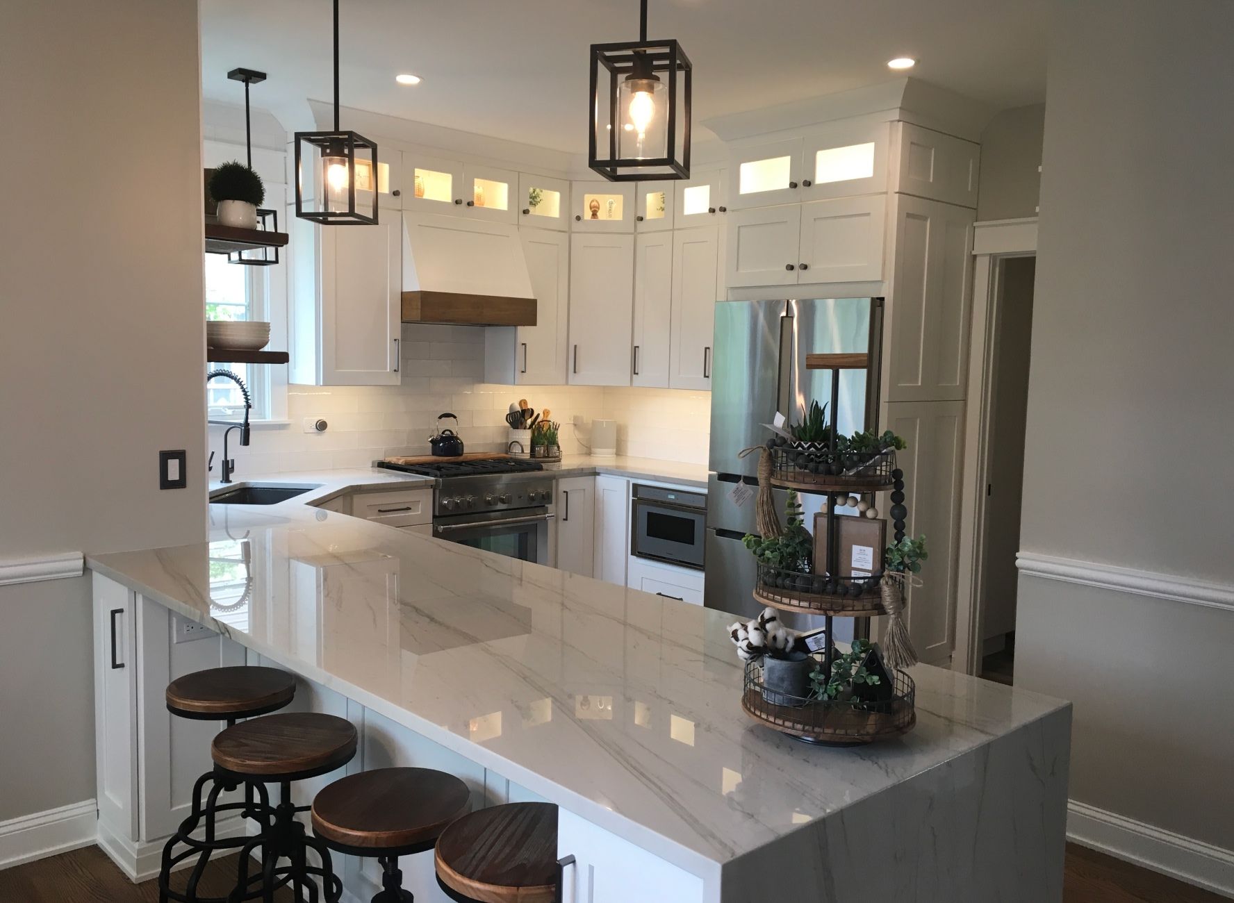 custom white and grey stone island in kitchen with brown wooden barstools