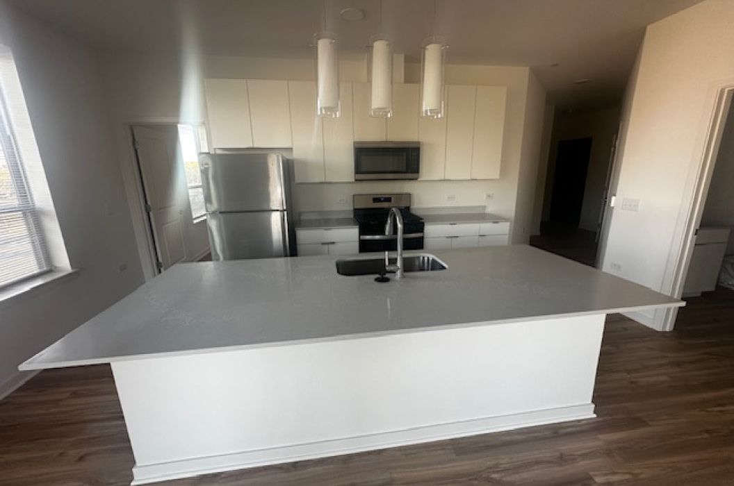 White Quartz Apartment kitchen island at 157+Cicero Apartments