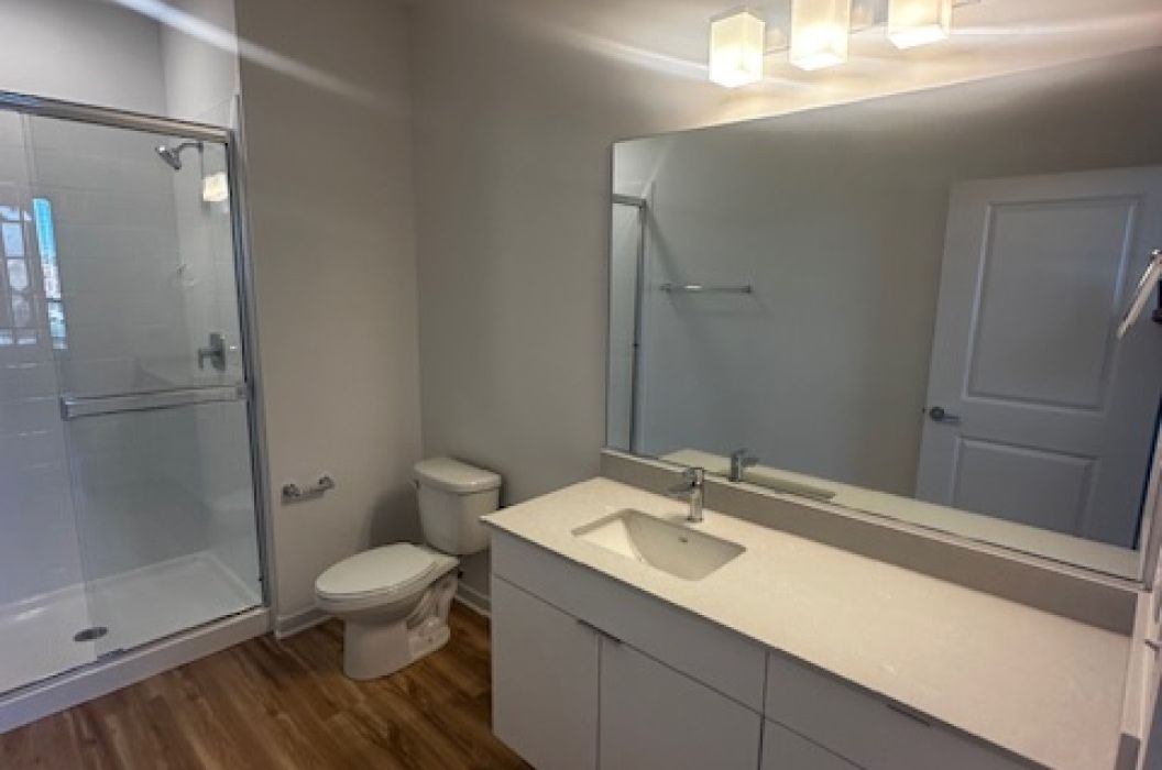 Apartment bathroom with walk-in shower and quartz countertop vanity at 157+Cicero Apartments in Oak Forest, IL.