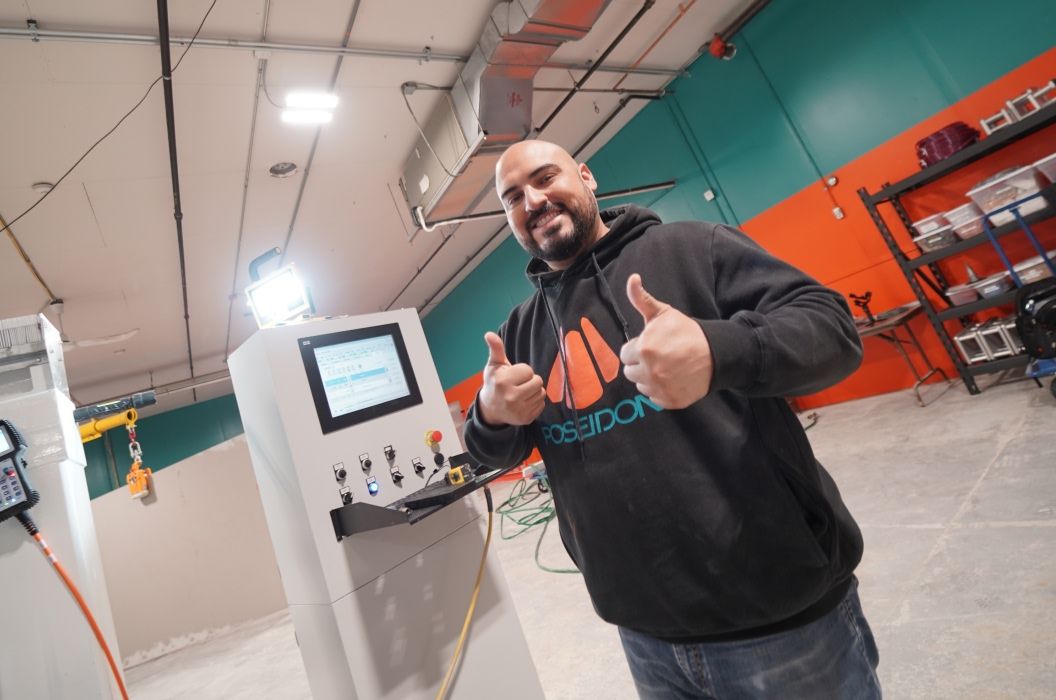 Engineer showing fabrication designs to coworker taking notes wearing an atlantis hat